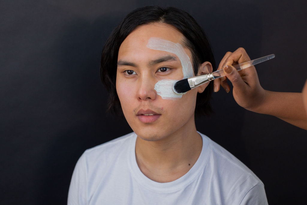 An esthetician applying a face mask on a client’s face