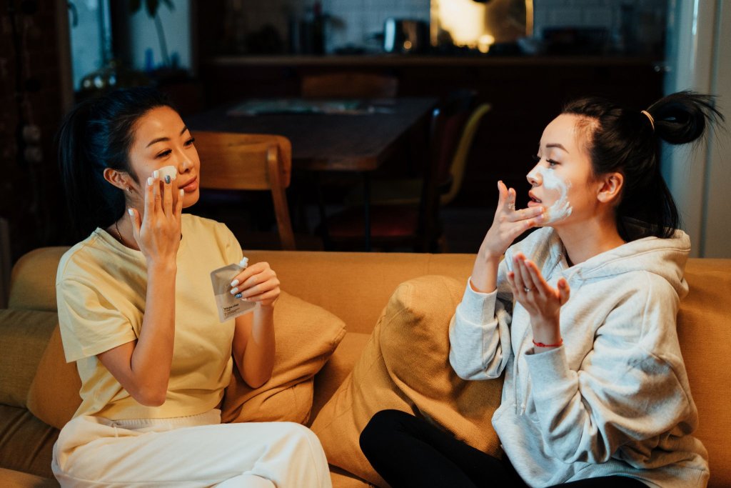 Two women applying face masks